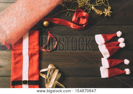Christmas tree toys handmade. Wooden background. Top view. Making New Year decoration. Christmas ornaments. Little Santa Claus hats.