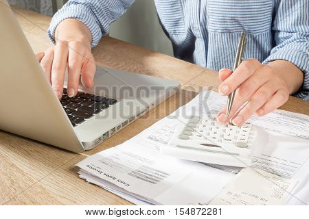 Hands Using Calculator And Laptop To Complete Accounts