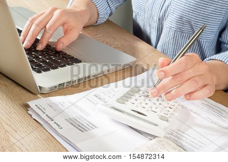 Person In Shirt At Desk Bookkeeping With Laptop And Calculator