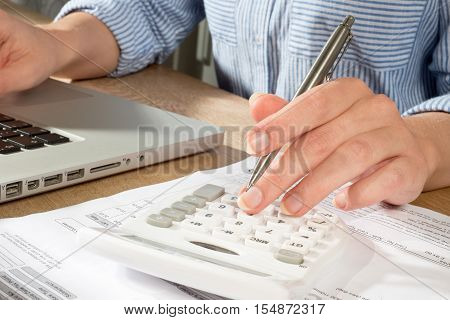 Person In Shirt At Table Accounting With Laptop And Calculator