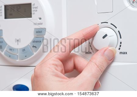 Hand Changing Setting With Dial On Boiler Or Appliance