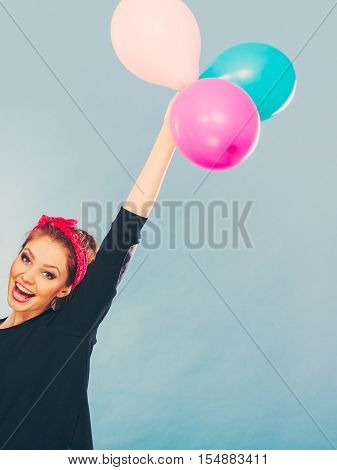 Craziness and lots of fun. Cute crazy joyful girl playing with colored balloons. Blonde playful retro style woman feel craze.