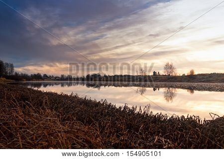 The water of the river Pyhajoki in the Northern Finland is reflecting the autumn sunrise. The mornings can be cold but there is no snow or ice yet.