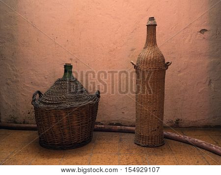 Picture of a two case-bottles of wine against the background of the beige - coloured wall. Background of a two case-bottles of wine in old cellar of the winery.