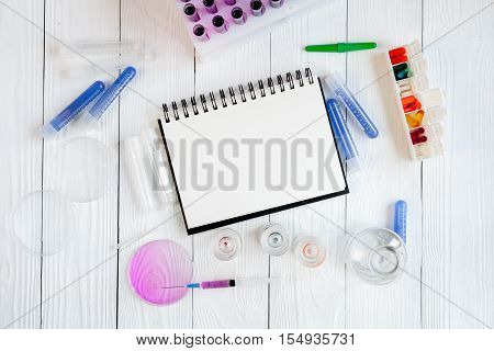 medical student working place with blank open notebook at wooden table top view