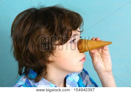 preteen handsome boy grimacing with icecream cone performing pinocchio close up funny photo