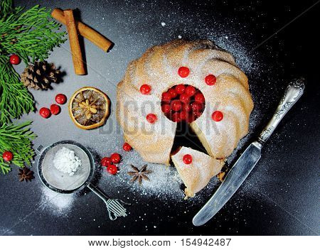 Christmas  bundt cake  with red berries on a black background