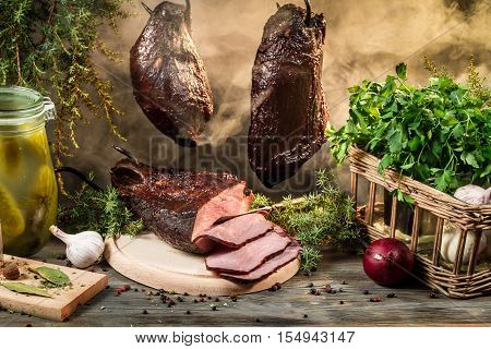 Rural smokehouse ham preparation for smoking on old wooden table