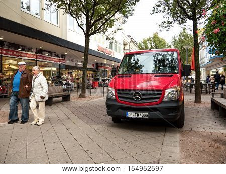 KEHL GERMANY - OCT 18 2016: red Mercedes-Benz delivery van in front of Woolworth retail store in typical German street with senior couple walking on a promenade
