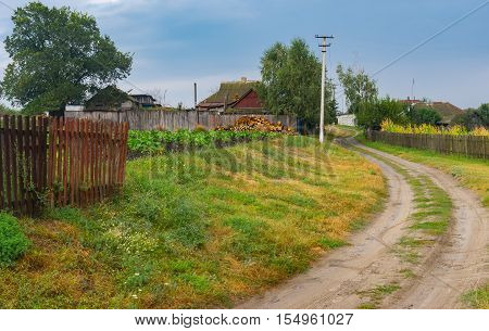 Autumnal scenery with earth road between streets in Boromlya village Sumskaya oblast Ukraine