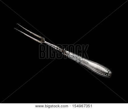 Vintage meat fork on a black background