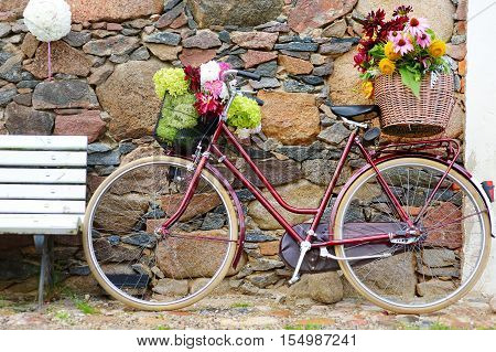 Vintage bicycle decorated with various flowers on summer day