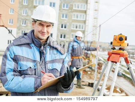 Two surveyors worker with theodolite