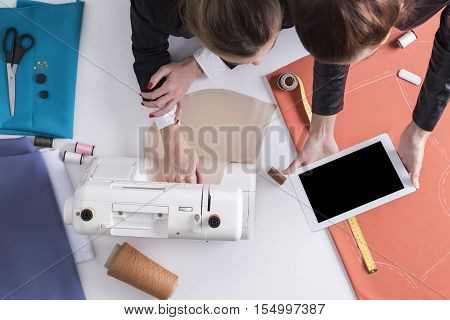 Woman Is Showing Tablet To Her Sewing Colleague