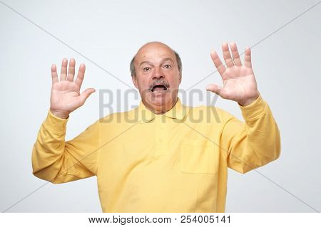 I'm Afraid. Portrait Of Senior Scared Man In Yellow Pulover. . Male Half-length Portrait.