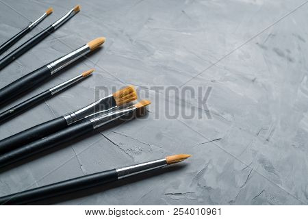 Painting Brusches On Gray Concrete Background. Flat Lay, Top View