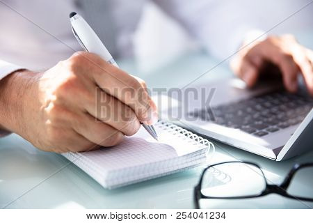 Businessman's Hand Writing In Diary