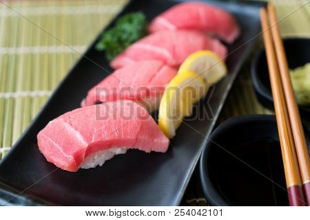 Otoro Tuna Sushi On Black Plate Along With Japanese Sauce And Green Leaf Decoration, Japanese Food, 