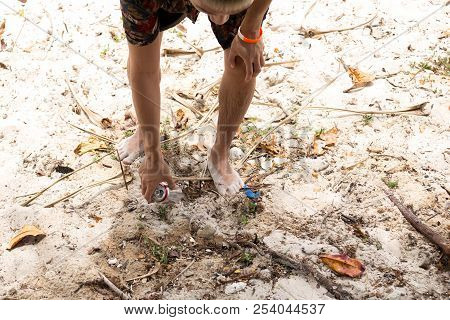 Trourist Man Picking Up Litter Can On The Beach.