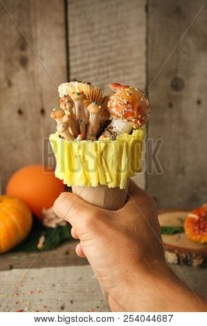 Fantastic Ice Cream With Candy Mashroom In Hand On Wooden Background, Concept Of Poisin, Nagic Food,