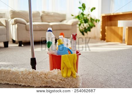 Cleaning Set For Different Surfaces In Orange Bucket And Mop On Floor In Living Room, Copy Space. Cl