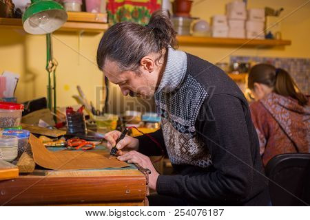 Skinner Making Decorative Details On Leather Playing Field