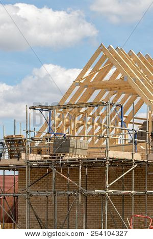 Scaffold Platform And Timber Roof Trusses On New Building Under Construction. Home Being Built On A 