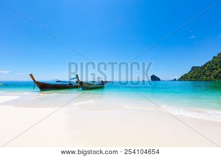 Longtail Boats Moored At Aonang Beach Against Blue Sky