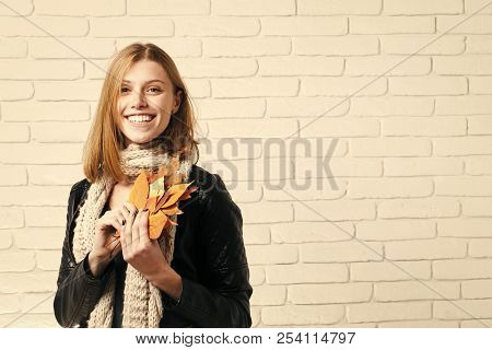 Season And Autumn Holiday. Beauty And Fashion. Girl With Orange Leaves At Brick Wall. Woman With Aut