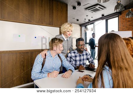 Attractive Female Boss Standing Between Her Male Workers