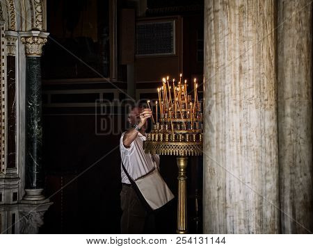 Athens, Greece - June 30, 2018. Parishioner Light Candles In The Nave Of The Metropolitan Cathedral 