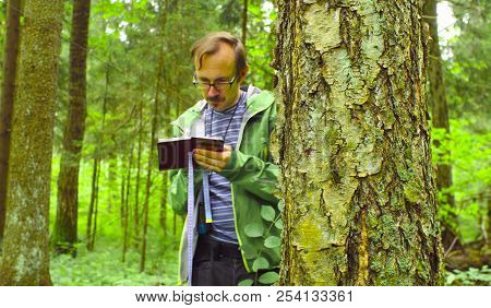 The Ecologist In A Forest Writing In Notebook.