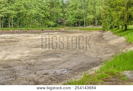 Dewatered And Excavated Lake Detail Near A Forest At Spring Time