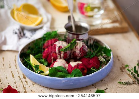 Beet Falafel With Tahina  Sauce And Green . Salad Selective Focus