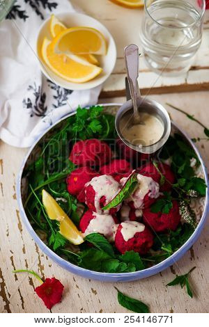 Beet Falafel With Tahina  Sauce And Green . Salad Selective Focus