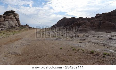 Monolithic Stones In The Steppes, Scant Vegetation, Blue Sky