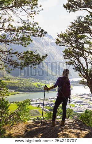Girl Hiker With A Backpack And Trekking Pole Standing And Looking On Romsdalsfjorden And Andalsnes, 