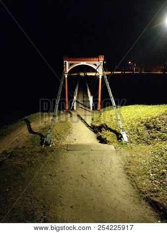 Viljandi Suspension Bridge At Nighttime, Lights Are Showing Upon The Entrance Of The Bridge