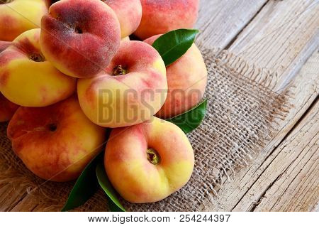 Chinese Flat Donut Peaches With Leaves On On Old Wooden Table Also Known As Saturn Donut, Doughnut P