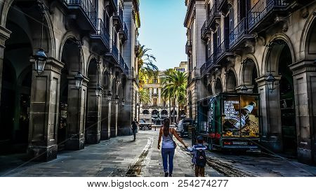 Barcelona, Spain - September 27 2016: A Woman Holds The Hand Of A Young Boy In The Gothic Quarter Of