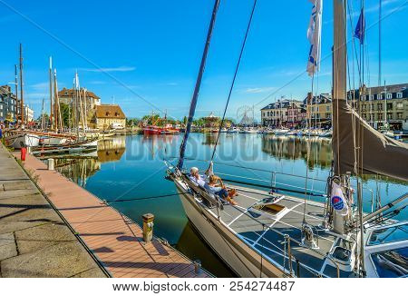 Honfleur, France ; September 17 2017: A Retired Couple Relax On A Sailboat In The Picturesque Old Pi