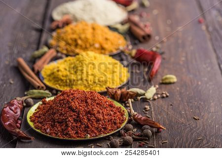 Heaps Of Various Ground Spices On Wooden Background. Georgian Spices, Indian Spices, Arabian Spices.