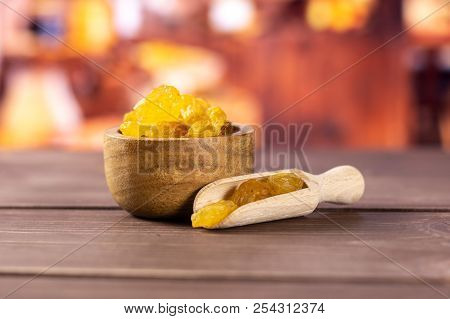 Lot Of Whole Dry Golden Raisins Sultana Variety Scoop With Wooden Bowl With Rustic Wood Kitchen In B