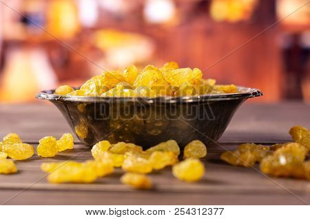 Lot Of Whole Dry Golden Raisins Sultana Variety In Old Iron Bowl With Rustic Wood Kitchen In Backgro