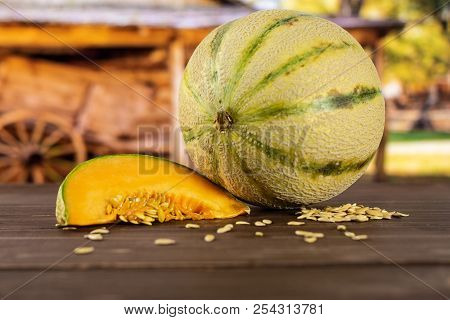 Group Of One Whole One Slice Of Fresh Melon Cantaloupe Variety With Seeds Around With Cart In Backgr