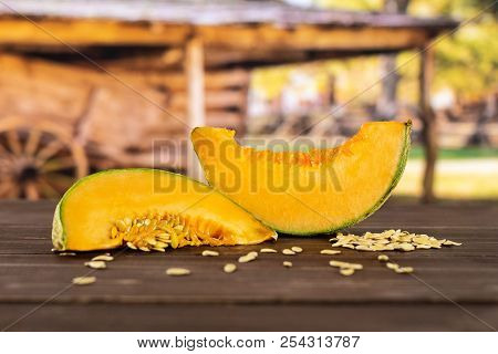 Group Of Two Slices Of Fresh Melon Cantaloupe Variety With Seeds Around With Cart In Background