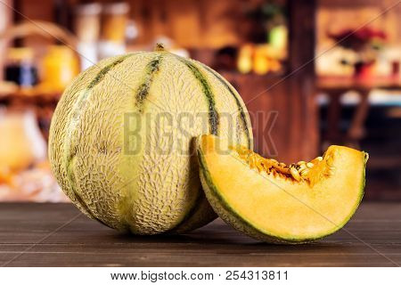 Group Of One Whole One Slice Of Fresh Melon Cantaloupe Variety With Rustic Wood Kitchen In Backgroun