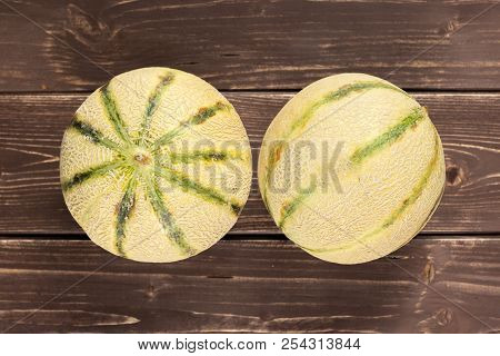 Group Of Two Whole Fresh Melon Cantaloupe Variety Flatlay On Brown Wood