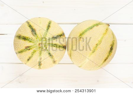 Group Of Two Whole Fresh Melon Cantaloupe Variety Flatlay On Grey Wood