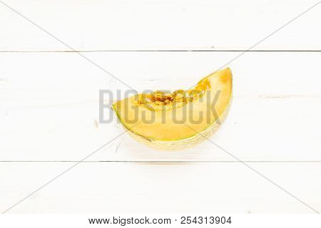 One Slice Of Fresh Melon Cantaloupe Variety Flatlay On Grey Wood